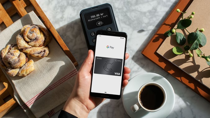 Mobil med Google Pay på café. Bild.